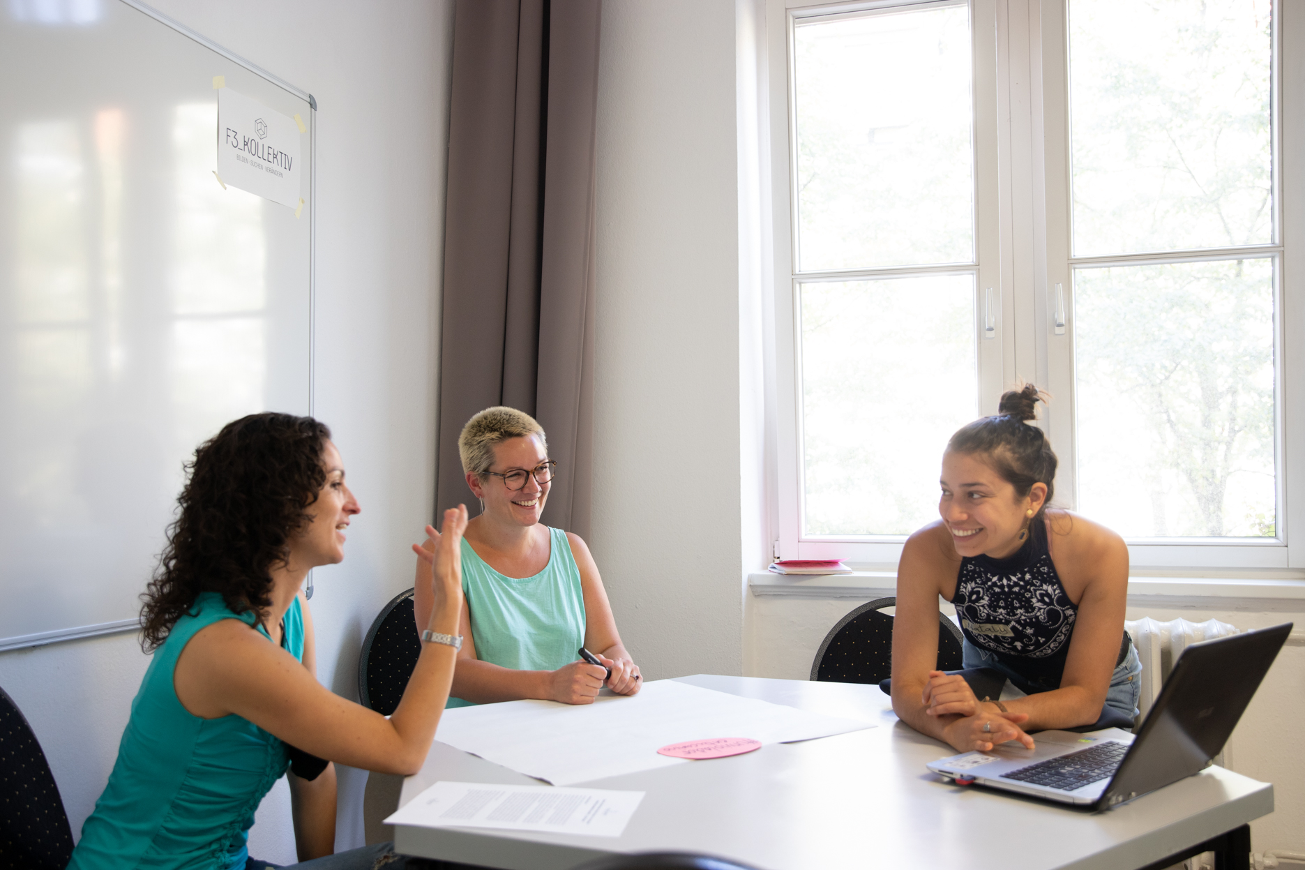 3 Frauen sitzen am Tisch und unterhalten sich